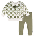 Children's outfit with checkered sweater and green pants on a white background