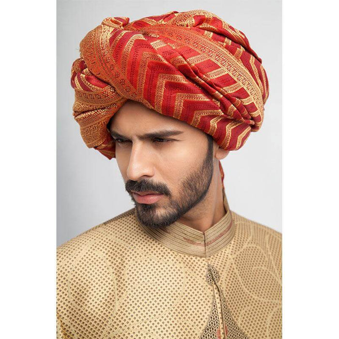 Antique gold, grey, and red brocade sherwani with a form-fitted cut, featuring intricate patterns and rich detailing for a regal appearance.