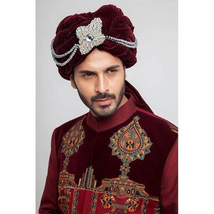 Close-up headshot of an Arsalan Iqbal teal paisley sherwani showcasing the silver embroidered mandarin collar and a white brocade turban with maroon velvet accents.