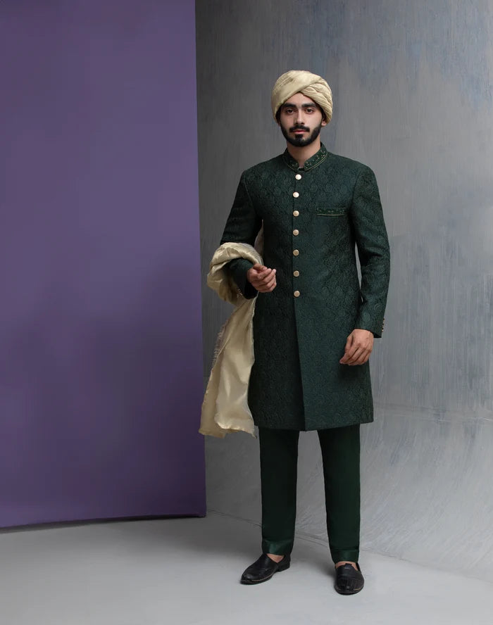 Arsalan Iqbal emerald green embroidered sherwani for men, featuring a side profile view with a beige silk turban and gold buttons