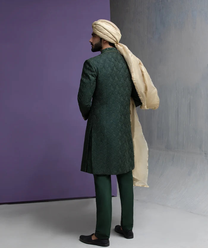 Arsalan Iqbal forest green designer sherwani with matching trousers, gold shawl, and traditional beige turban in a full-length shot