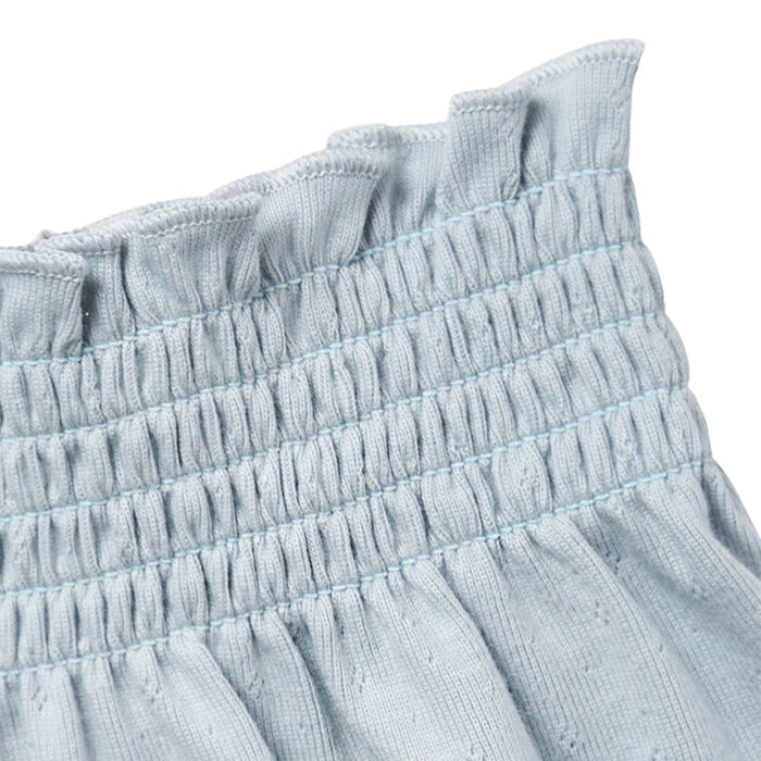 Close-up of light blue fabric with ruffled texture on a white background