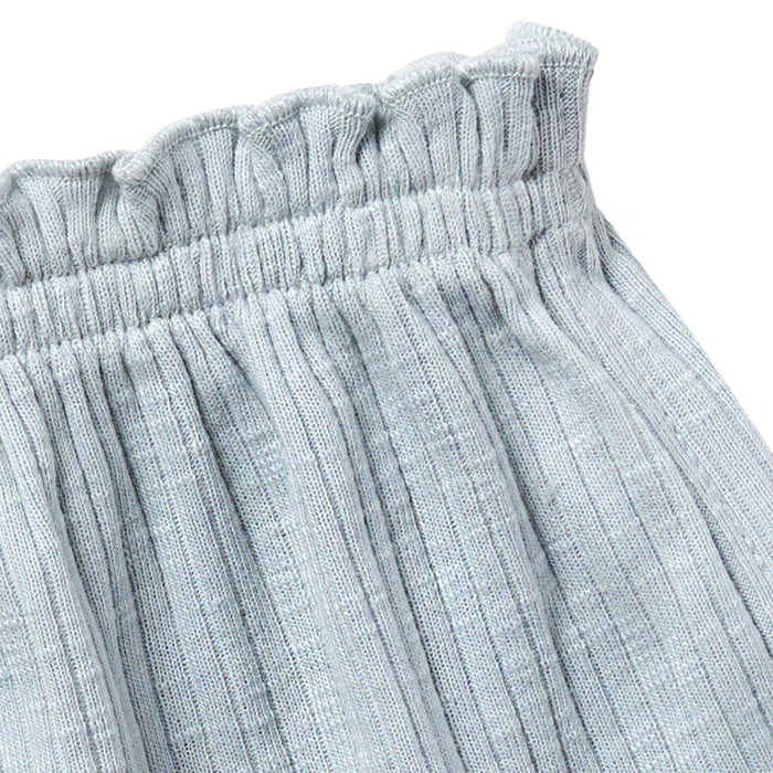 Close-up of light gray textured pants with an elastic waistband on a white background