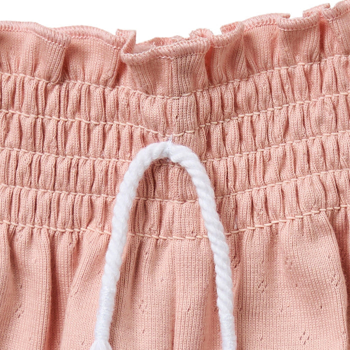Close-up of pink textured fabric with a white drawstring