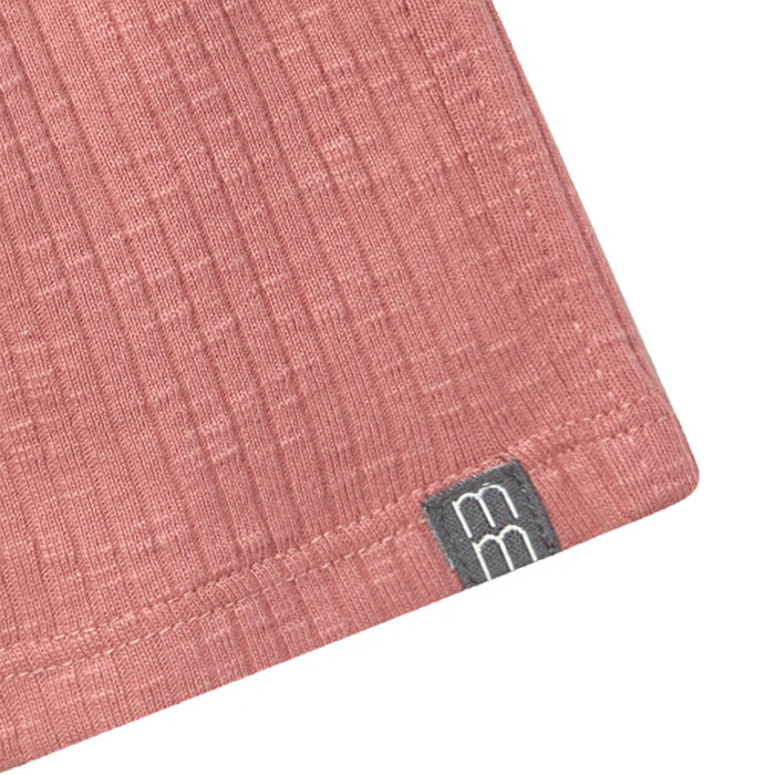 Close-up of a pink fabric with a brand logo on a white background