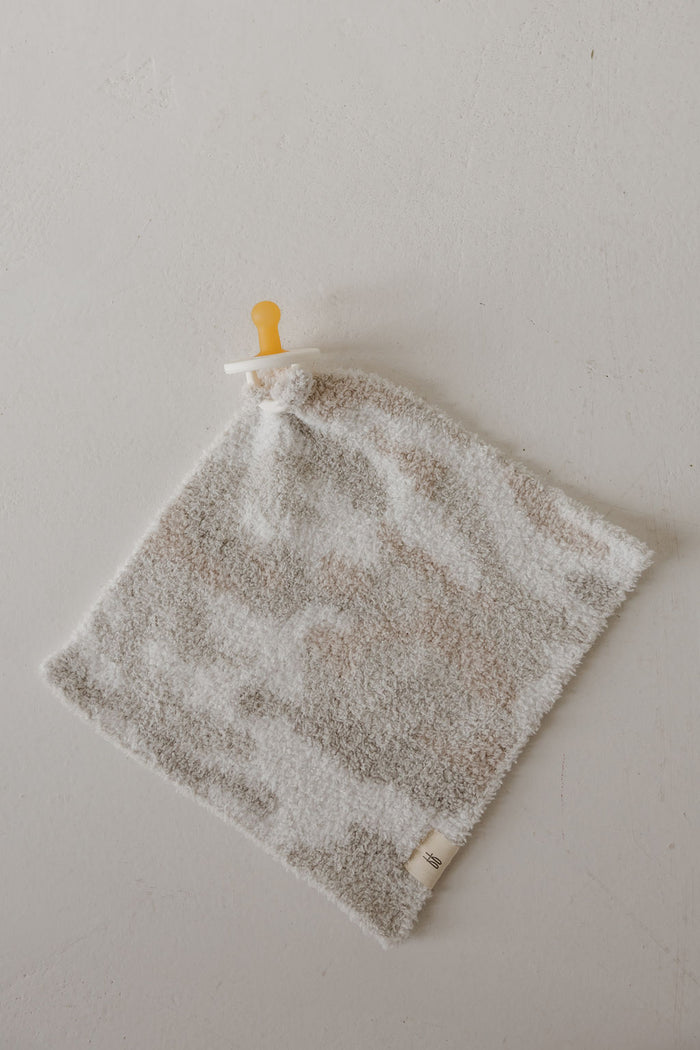 The forever french baby Lovey | Camo 2.0 is a soft, square microfiber plush with a neutral camo pattern and an attached pacifier, perfect for comfort and security.