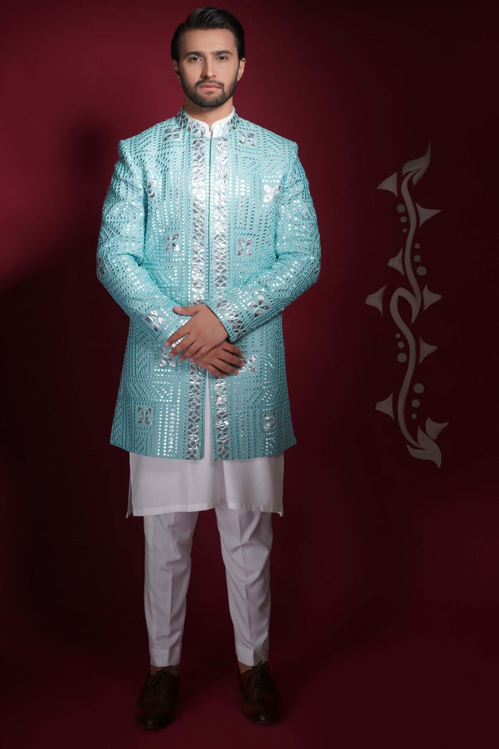 Arsalan Iqbal ice-blue prince coat featuring silver mirror-work in a geometric grid pattern, worn over a white long tunic and trousers.