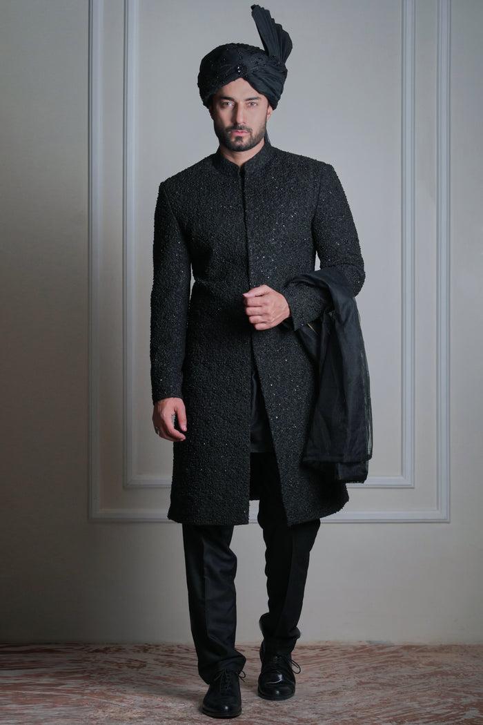 Male model wearing a black sherwani with turban by Arsalan Iqbal, premium luxury groom and wedding menswear