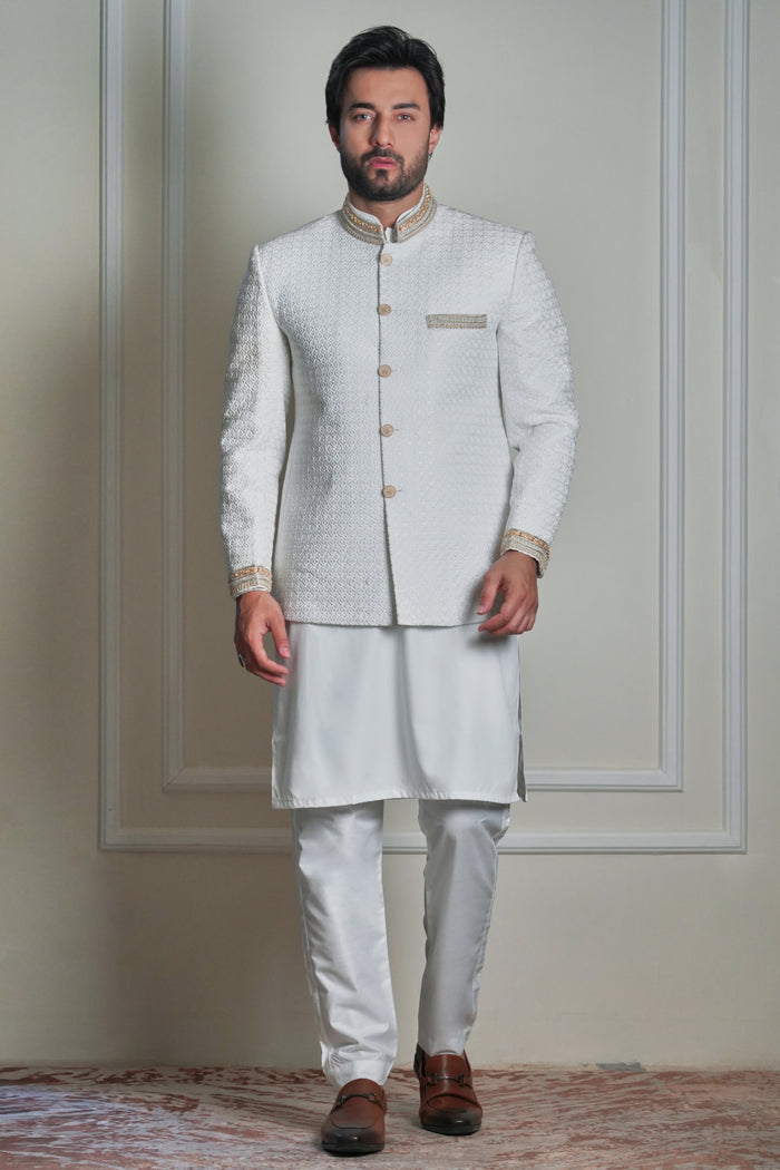 Men’s ivory jacquard prince coat with gold detailing, styled with matching kurta and churidar, formal wedding wear look.