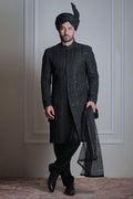 Male model wearing a black sherwani with turban by Arsalan Iqbal, luxury South Asian wedding menswear.
