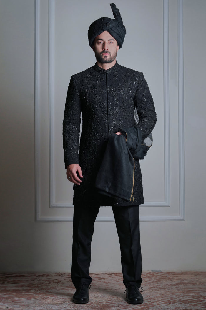 Male model wearing a black embroidered sherwani with turban by Arsalan Iqbal, luxury groom and wedding menswear